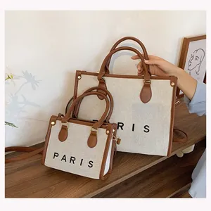 Set of two canvas tote bags in different sizes featuring PARIS print and brown trim