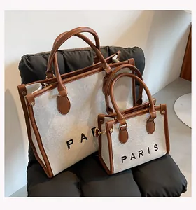 Two sizes of canvas tote bags with brown leather trim and PARIS print detail