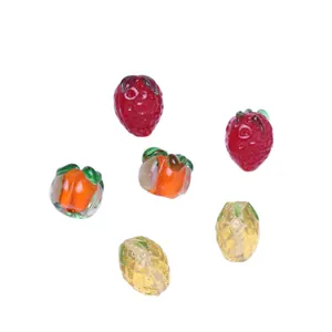 Assorted mini fruit lampwork glass beads for DIY jewelry making on a pure white background