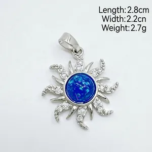 Vue détaillée d'un pendentif soleil rétro avec opale bleue et pierres blanches.