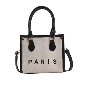 Stylish canvas tote bag with bold PARIS print and black leather trim for modern women