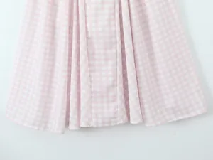 Detailed close-up of pink and white gingham pattern on a flowing summer dress hem