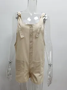 Front view detail of a beige cotton linen jumpsuit with front pockets and tie straps