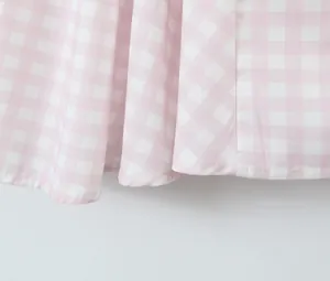 Close-up of pink and white gingham fabric hem showing pleated texture