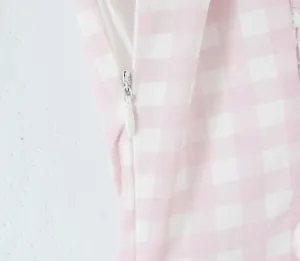 Close-up detail of the smooth invisible side zipper on a pink gingham check summer dress