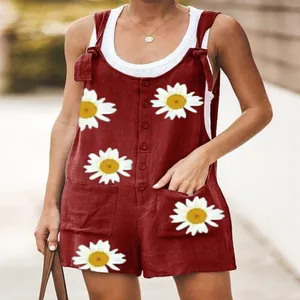 Detailed view of women's red cotton linen romper featuring large white daisy floral prints.