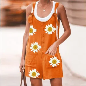 Close-up detail showing the orange daisy print cotton linen romper with patch pockets