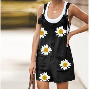 Detail showing a woman wearing black daisy print cotton linen overalls with pockets