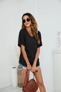 Woman wearing casual black loose V-neck cotton T-shirt in minimalist interior setting