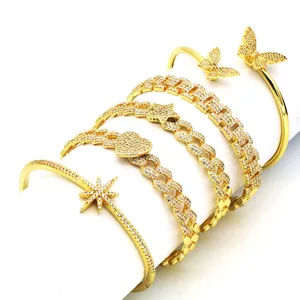 Close-up of gold-plated rhinestone bracelets with star, heart, and butterfly charms.