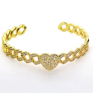 Gold-tone open cuff bracelet featuring a micro-paved crystal heart and chain link design.