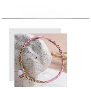 Handmade woven bracelet detail made with 0.6mm pink jade thread and a single bead.