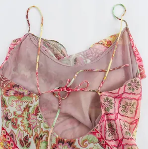 Close-up of backless floral slip dress showing thin straps and tie-back detail.