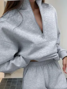Dettaglio di una tuta sportiva grigia a due pezzi con felpa a mezza zip e pantaloni