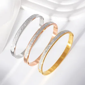 Close-up of three stainless steel stardust bangles in silver, gold, and rose gold.