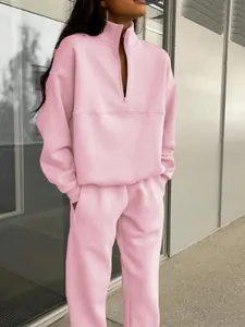 Dettaglio della tuta rosa con maglione a mezza zip e pantaloni coordinati su modella.
