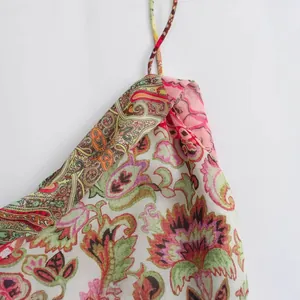 Close-up detail of a colorful paisley print dress with delicate spaghetti straps
