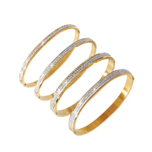 Set of four luxury gold titanium steel bangles with sparkling rhinestone starry sky design.