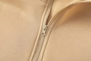 Dettaglio macro della cerniera in metallo liscia su morbido tessuto beige felpato