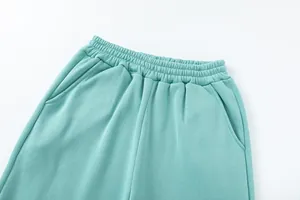 Dettaglio della vita elastica e delle tasche laterali sui pantaloni sportivi verde menta