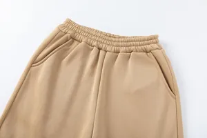 Dettaglio della vita elastica e delle tasche laterali su pantaloni casual in tinta unita