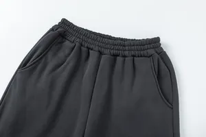 Dettaglio ravvicinato dei pantaloni della tuta grigio antracite con vita elastica.