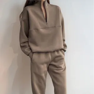 Tuta sportiva da donna due pezzi con felpa a mezza zip e pantaloni coordinati color beige.