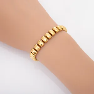 Détail rapproché d'un bracelet moderne en acier titane plaqué or porté au poignet avec maillons