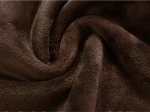 Gros plan sur la texture du tissu polaire marron doux pour la doublure d'un gilet chaud