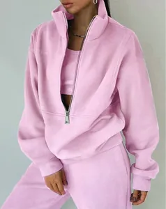 Dettaglio di un set da donna in pile rosa con felpa a mezza zip e pantaloni sportivi.