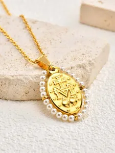 Macro view of gold-tone oval pendant with pearl border and religious symbols