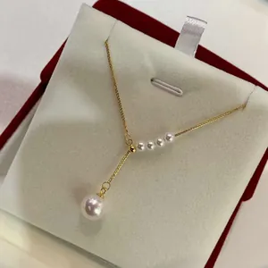 Detailed macro view of elegant gold-plated Y-chain necklace with round white pearls