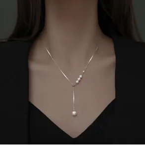 Élégant collier à pampilles de perles en argent en forme de Y, vue détaillée sur le cou.