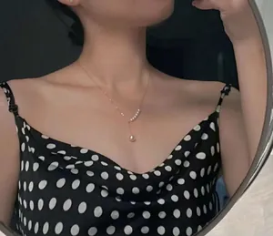 Detailed view of a silver-plated mermaid tear pearl pendant necklace on a model