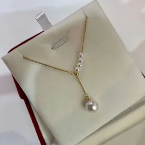 Close-up of a Y-shaped gold-plated necklace featuring flawless round freshwater pearls