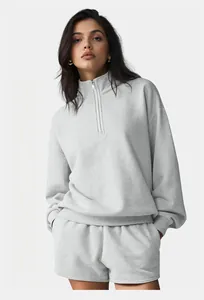 Front view of a model wearing a grey half-zip sweatshirt and matching loungewear shorts