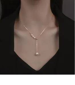 Élégant collier en perles dorées en forme de Y avec pompon sur le cou