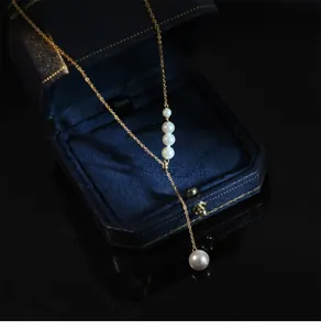 Collier à pampilles en perles dorées sur une luxueuse boîte à bijoux bleu marine