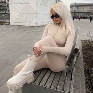Dettaglio tuta intera a costine beige a maniche lunghe con mezza zip e occhiali