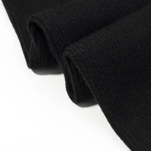 Primo piano macro della trama del tessuto a maglia a coste nere per tuta da donna