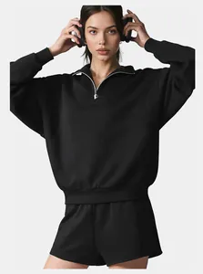 Close-up detail of a black half-zip thermal sweatshirt and sports shorts
