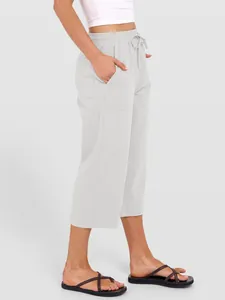 Detail view of women's grey linen wide-leg pants with side pockets and drawstring.