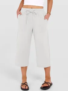 Detail view of women's white wide-leg linen pants with drawstring waist and pockets