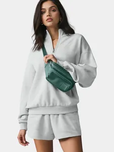 Women's oversized grey half-zip sweatshirt and shorts set for casual athletic wear