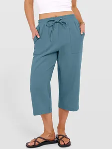 Close-up detail of women's blue cotton linen cropped trousers with drawstring waist and pockets