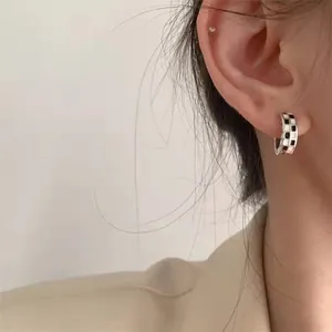 Close-up of S925 silver checkerboard hoop earring worn on an ear, vintage style