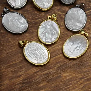 Close-up detail of carved religious figures on natural mother-of-pearl oval shell pendants.