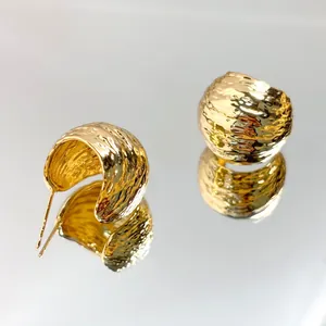 Detail view of 18K gold-plated textured dome stud earrings with a stylish hammered finish