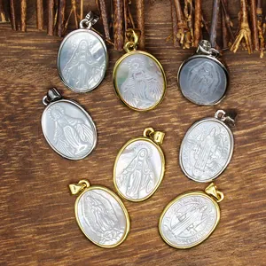 Close-up macro view of natural mother of pearl oval pendants featuring detailed religious carvings