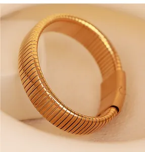 Macro detail of high-quality gold plated elastic snake-shaped bracelet on soft fabric
